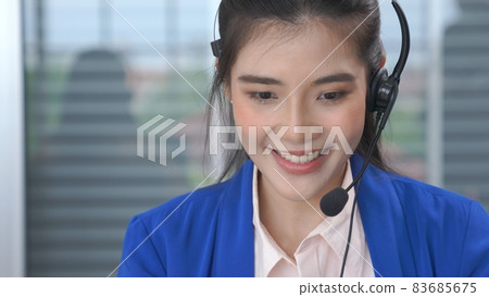 Businesswoman wearing headset working actively in office 83685675