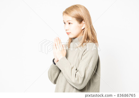 一個穿毛衣的年輕女人要她把手掌放在一起 一個穿毛衣的年輕女人要她把手掌放在一起 83686765