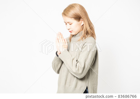 一個穿毛衣的年輕女人要她把手掌放在一起 一個穿毛衣的年輕女人要她把手掌放在一起 83686766