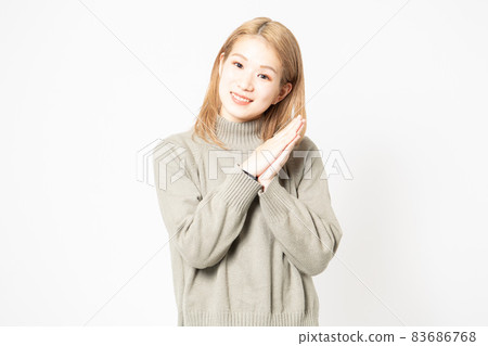 一個穿毛衣的年輕女人要她把手掌放在一起 一個穿毛衣的年輕女人要她把手掌放在一起 83686768