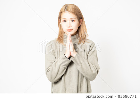 一個穿毛衣的年輕女人要她把手掌放在一起 一個穿毛衣的年輕女人要她把手掌放在一起 83686771
