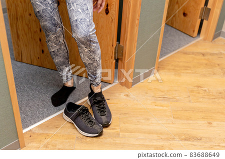 A woman (sneakers) coming out of the changing room 83688649