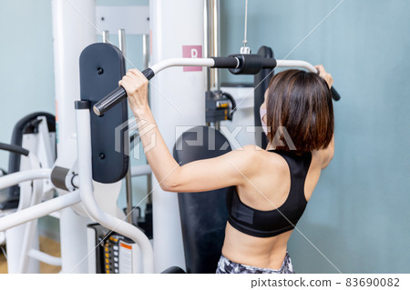 A woman training her back in a gym A woman training her back in a gym 83690082