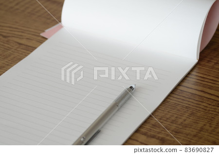 There is a stationery and a pen on the desk. There is a stationery and a pen on the desk. 83690827