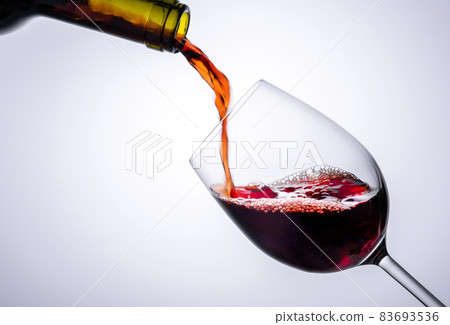 Red wine poured in a glass isolated on white background Red wine poured in a glass isolated on white background 83693536