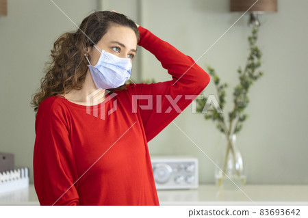 Young woman wearing a mask to protect herself against the coronavirus at home 83693642