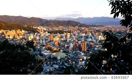 Autumn Matsuyama cityscape illuminated by the setting sun seen from Matsuyama Castle in Matsuyama City, Ehime Prefecture [September] 83693987