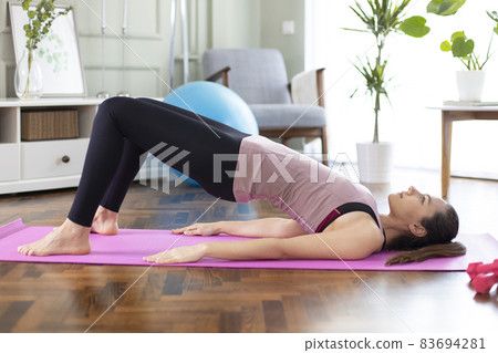 Beautiful sporty woman in sportswear doing exercises to build muscles at home 83694281