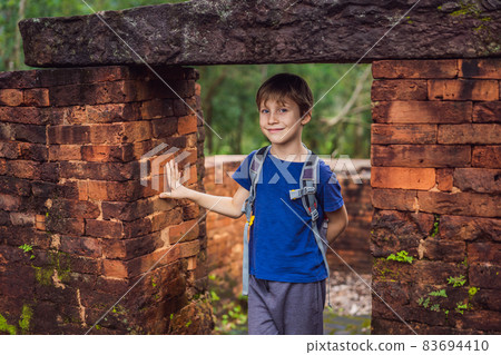 Boy tourist in Temple ruin of the My Son complex, Vietnam. Vietnam opens to tourists again after quarantine Coronovirus COVID 19 Boy tourist in Temple ruin of the My Son complex, Vietnam. Vietnam opens to tourists again after quarantine Coronovirus COVID 19 83694410