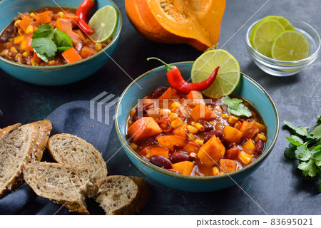 Hot vegan chili with Hokkaido pumpkin from the vegan cuisine with lime and coriander served Hot vegan chili with Hokkaido pumpkin from the vegan cuisine with lime and coriander served 83695021