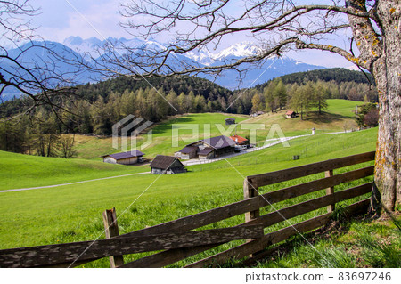 Tirol, Oostenrijk. April 2010. Hill landscape in Austria with snow-capped mountain peaks in the background. Tirol, Oostenrijk. April 2010. Hill landscape in Austria with snow-capped mountain peaks in the background. 83697246