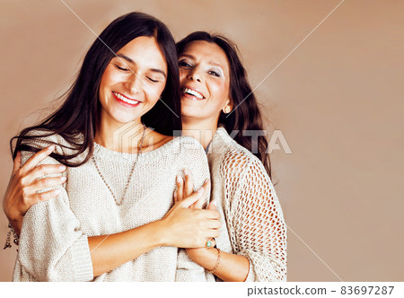 cute pretty teen daughter with mature mother hugging, fashion style brunette makeup close up tann s together, warm colors cute pretty teen daughter with mature mother hugging, fashion style brunette makeup close up tann s together, warm colors 83697287