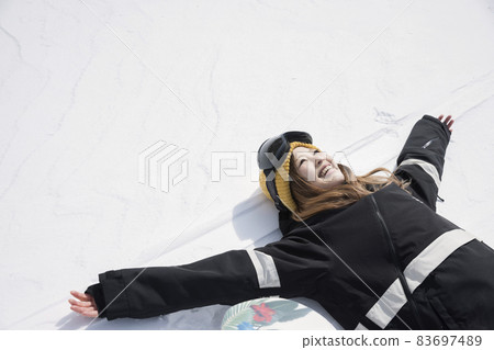 A young woman lying on the slopes, a snowboard girl 83697489