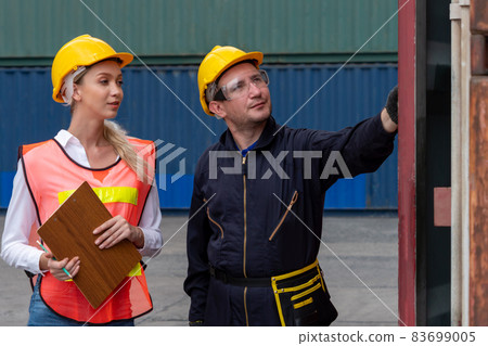 Industrial worker works with co-worker at overseas shipping container yard 83699005