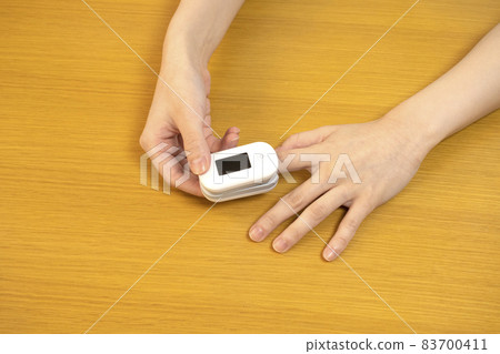 Woman wearing a pulse oximeter 83700411