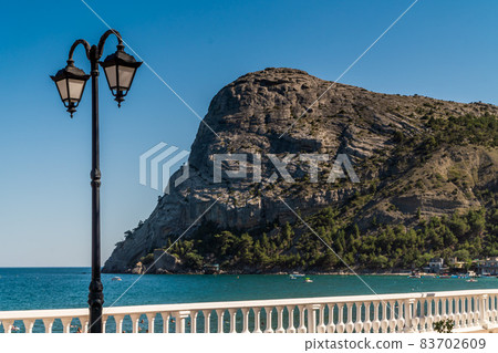 The Republic of Crimea. July 15, 2021. Picturesque view in sunny weather of Mount Koba-Kaya and the embankment in the village of Novy Svet. 83702609