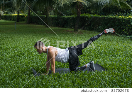 Sporty active young man in sportswear doing sport exercises in the park. Muscular fit man doing exercises outdoors. Healthy lifestyle concept, sport 83702678