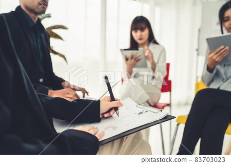 Business people proficiently discuss work project while sitting in circle 83703023