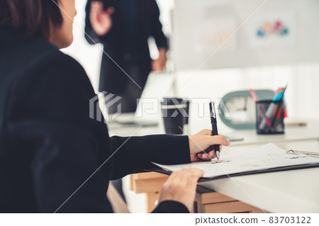 Businesswoman in business meeting writing paper proficiently at office room . 83703122
