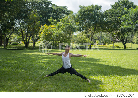 Sporty active young man in sportswear doing sport exercises in the park. Fit caucasian man stretching on the grass outdoors. Healthy lifestyle concept Sporty active young man in sportswear doing sport exercises in the park. Fit caucasian man stretching on the grass outdoors. Healthy lifestyle concept 83703204