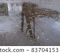 reflection of a tree and a building in an autumn puddle 83704153