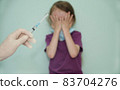 the child covered his face with his hands as a sign against the vaccine 83704276