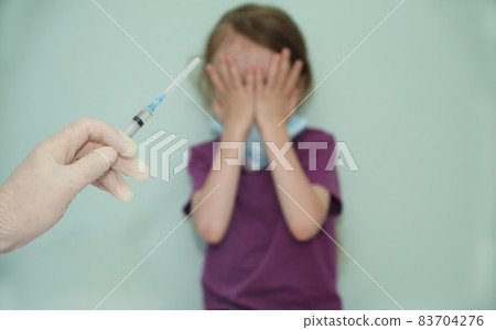 the child covered his face with his hands as a sign against the vaccine 83704276