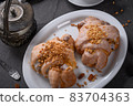 Tasty traditional polish croissants  - Croissant of Saint Martin (Rogal Swietomarcinski) with white poppy seeds, nuts and cup of coffee on a dark slate stone 83704363