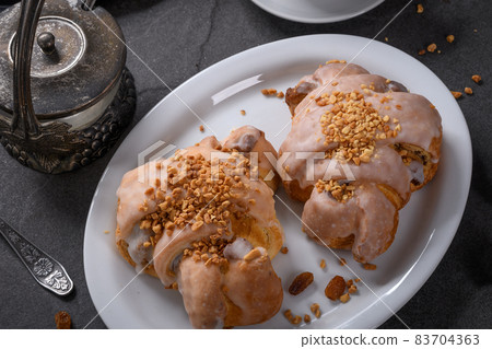 Tasty traditional polish croissants  - Croissant of Saint Martin (Rogal Swietomarcinski) with white poppy seeds, nuts and cup of coffee on a dark slate stone 83704363