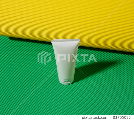 empty white plastic tubes for cosmetics on a green yellow background. Packaging for cream, gel, serum, advertising and product promotion, mock up empty white plastic tubes for cosmetics on a green yellow background. Packaging for cream, gel, serum, advertising and product promotion, mock up 83705032