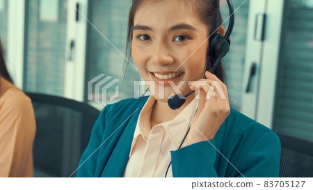 Businesswoman wearing headset working actively in office Businesswoman wearing headset working actively in office 83705127