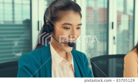 Businesswoman wearing headset working actively in office Businesswoman wearing headset working actively in office 83705129