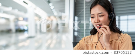 Office worker wearing headset working actively in office Office worker wearing headset working actively in office 83705132