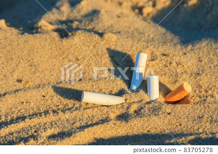 Cigarette butts in yellow sand on sea beach on coast. Concept of environmental pollution. Problem of humanity. Cigarette smoking, bad habit. Nicotine addiction. Garbage Cigarette butts in yellow sand on sea beach on coast. Concept of environmental pollution. Problem of humanity. Cigarette smoking, bad habit. Nicotine addiction. Garbage 83705278