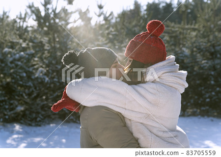Young couple in love outside and winter kissing. Happy lovers in winter forest Young couple in love outside and winter kissing. Happy lovers in winter forest 83705559