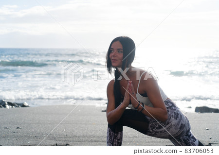 woman in sport clothes practicing yoga and meditating on beach in morning woman in sport clothes practicing yoga and meditating on beach in morning 83706053