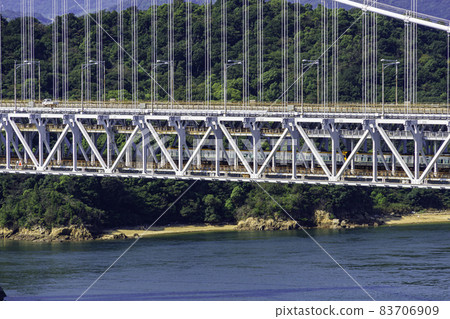 穿過岡山縣倉敷市瀨戶橋的火車和汽車 83706909