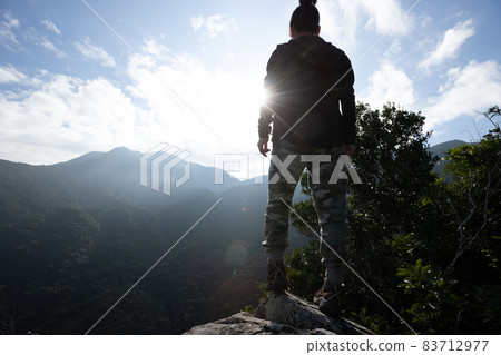 Successful hiker on sunrise mountain top cliff edge Successful hiker on sunrise mountain top cliff edge 83712977