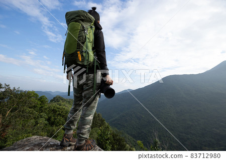 Successful hiker enjoy the view on mountain top cliff edge Successful hiker enjoy the view on mountain top cliff edge 83712980