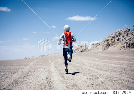 Fitness woman trail runner cross country running on sand desert Fitness woman trail runner cross country running on sand desert 83712999