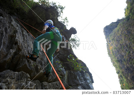 Female rock climber on cliff 83713007