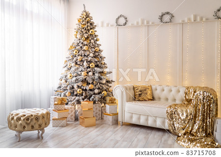 white christmas interior with new year tree decorated. Gold pouf, textile, presents under the tree white christmas interior with new year tree decorated. Gold pouf, textile, presents under the tree 83715708