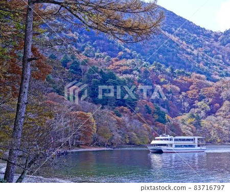 A view of the autumn leaves on the shore of Lake Chuzenji and a sightseeing boat, rectangular composition 83716797