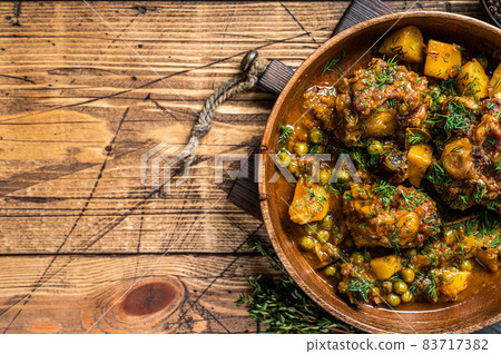 Veal beef oxtails tails stew with vegetables in a wooden plate. wooden background. Top view. Copy space Veal beef oxtails tails stew with vegetables in a wooden plate. wooden background. Top view. Copy space 83717382