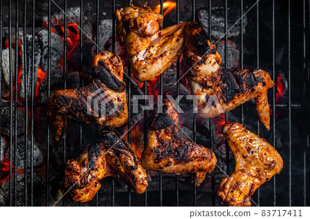 Chicken wings on barbecue, outdoor BBQ grill with fire. Top view 83717411
