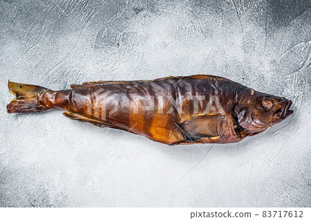 Hot smoked whole fish on kitchen table. White background. Top view Hot smoked whole fish on kitchen table. White background. Top view 83717612