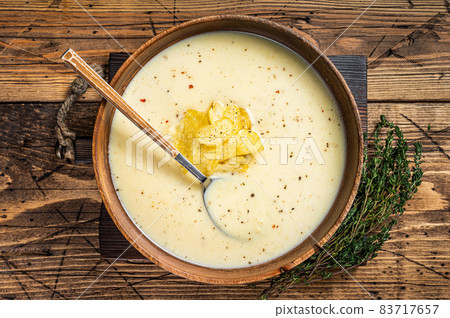 Cream potato soup with potato chips in wooden plate. wooden background. Top view Cream potato soup with potato chips in wooden plate. wooden background. Top view 83717657
