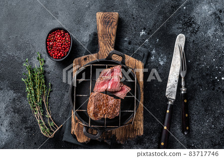 Grilled fillet mignon beef steak on a grill. Black background. Top view 83717746
