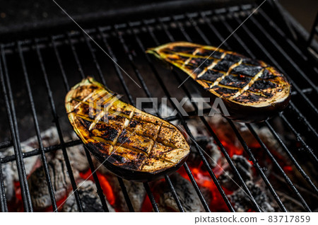 Eggplant on barbecue, outdoor BBQ grill with fire. Top view 83717859