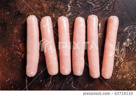 Raw chicken and turkey meat sausages on butcher table. Dark background. Top view Raw chicken and turkey meat sausages on butcher table. Dark background. Top view 83718110
